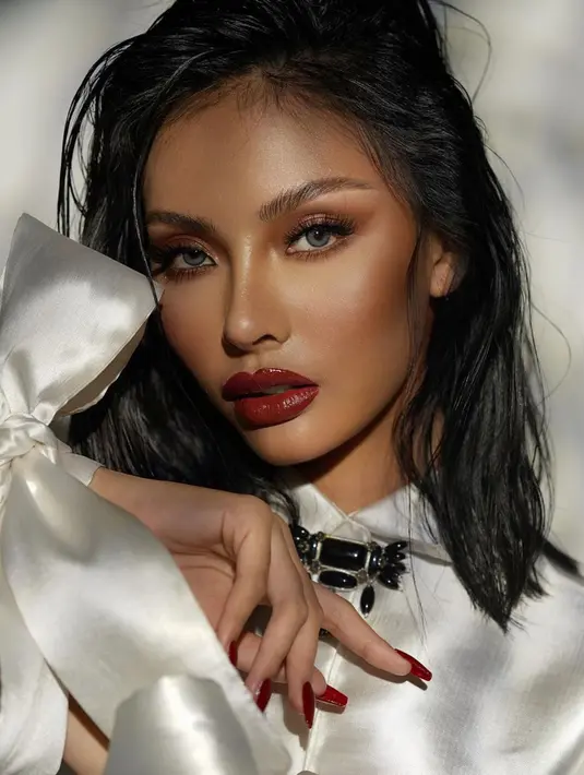 Makeup natural glam yang memberi mood super bold dengan pengaplikasian lipstik merah dan rambut yang terlihat messy (Foto: Instagram @andina_julie)