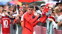 Pemain Bayern Munchen, Philippe Coutinho, menyapa suporter saat latihan perdananya di Munchen, Selasa (20/8). Bintang Brasil ini didatangkan dari Barcelona. (AFP/Christof Stache)