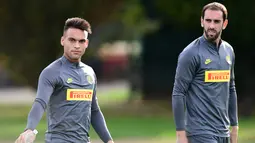 Pemain depan Inter Milan Lautaro Martinez (kiri) dan bek Diego Godin tiba menghadiri sesi latihan di pusat pelatihan Suning di Appiano Gentile, Como, Italia (22/10/2019). Inter Milan akan bertanding melawan wakil Jerman, Borussia Dortmund pada grup F Liga Champions. (AFP/Miguel Medina)