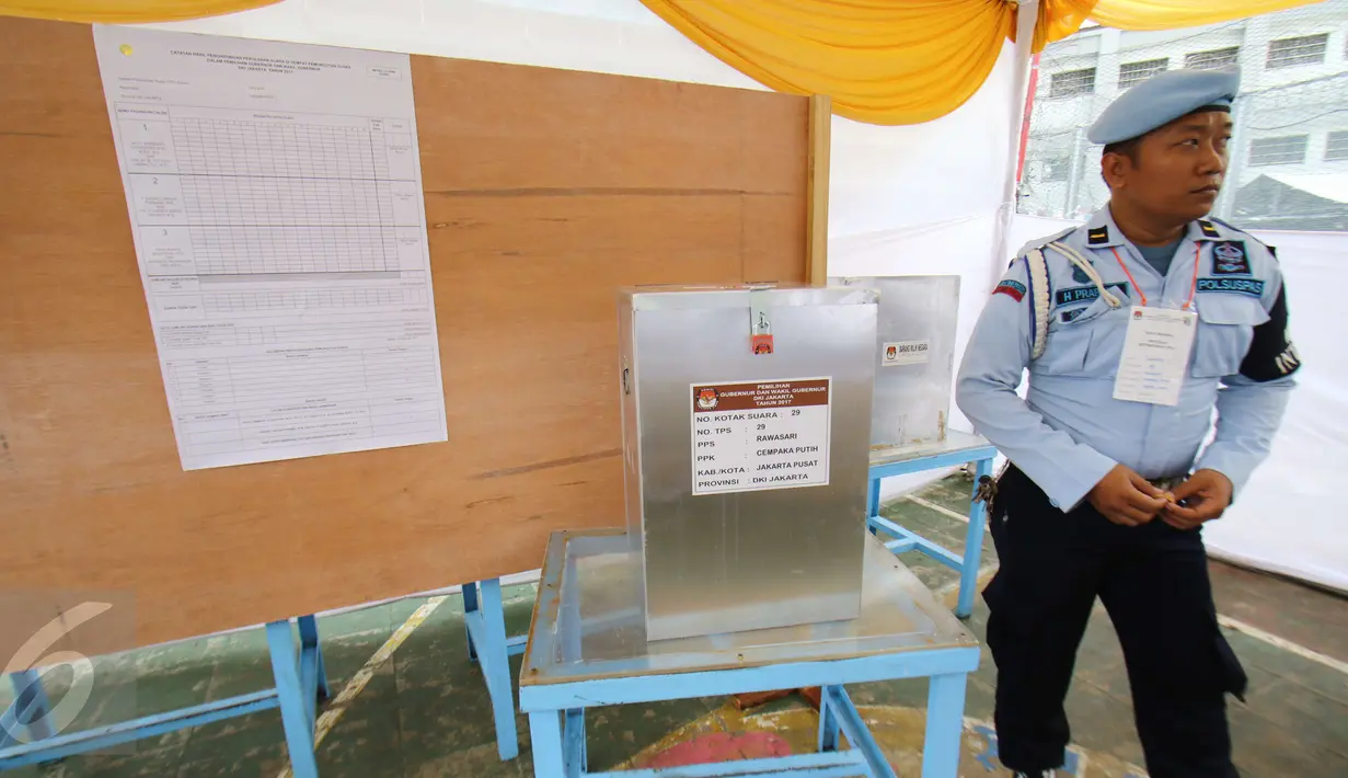 Petugas menjaga kotak suara di di TPS 28 Lembaga Pemasyarakatan Klas 1 Narkoba, Salemba, Jakarta, Rabu(15/2). Paslon nomor urut 2 mengungguli dengan total suara 77 suara. (Liputan6.com/Helmi Afandi)