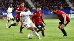 Pemain Real Madrid Marco Asensio (kiri) melindungi bola dari pemain Osasuna Ruben Garcia pada pertandingan sepak bola La Liga Spanyol di Stadion El Sadar, Pamplona, Spanyol, 20 April 2022. Real Madrid menang 3-1. (AP Photo/Alvaro Barrientos)