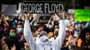 Seorang pria memegang skateboard bertuliskan nama George Floyd ketika berunjuk rasa dalam mendukung Floyd dan Regis Korchinski-Paquet dan protes terhadap rasisme, ketidakadilan dan kebrutalan polisi, di Vancouver (31/5/2020). (Darryl Dyck/The Canadian Press via AP)