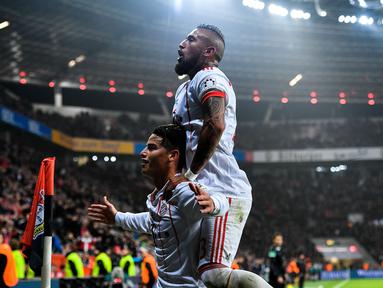 Pemain Bayern Munchen,  James Rodriguez merayakan gol bersama rekannya Arturo Vidal (kanan) saat melawan Bayer Laverkusen pada lanjutan Budesliga di Bay Arena, Laverkusen, (12/1/2018). Bayern Munchen menang 3-1. (AFP/Sascha Schuermann)