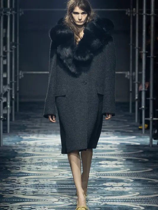 Pesona dalam koleksi ini tidak mencolok atau konvensional, kemewahan itu ada dalam detailnya, dalam hiasan kecil namun mencolok yang mengganggu keaslian pakaian. Perhiasan diintegrasikan ke dalam pakaian rajut, pita didekonstruksi, dan hiasan ditempatkan dengan asimetri yang disengaja. [Dok/Prada].