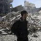Polisi Palestina berdiri dekat reruntuhan bangunan kantor The Associated Press yang hancur akibat serangan udara Israel di Kota Gaza, Sabtu, 15 Mei 2021. Gedung tersebut juga menampung Al Jazeera dan sejumlah kantor serta apartemen. (AP Photo/Khalil Hamra)