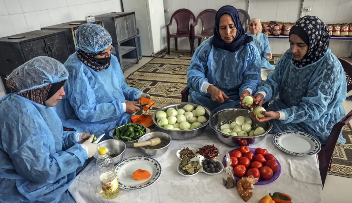 Para wanita membuat maftoul atau couscous di Khan Yunis, Jalur Gaza, Palestina, 10 Januari 2022. Secara tradisional, makanan ini dimasak menggunakan alat kukus. (SAID KHATIB/AFP)