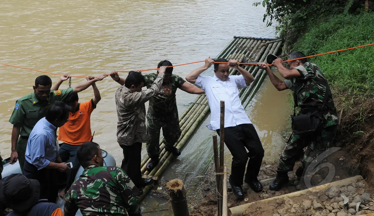 Menteri Pendidikan dan Kebudayaan, Anies Baswedan berusaha sampai ke daratan usai menyeberangi sungai dengan perahu karet, Lebak, Banten, Senin (16/3/2015). Menteri Anies meninjau jembatan yang roboh di Lebak(Liputan6.com/Herman Zakharia)