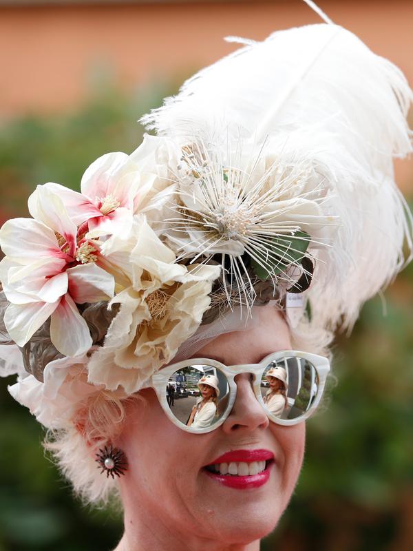 Seorang wanita mengenakan topi atau fascinator unik bermotif bunga saat menghadiri ajang pacuan kuda Royal Ascot di Ascot, Inggris, Selasa (18/6/2019). Royal Ascot menjadi ajang bagi wanita Inggris untuk tampil dengan fascinator unik. (AP Photo/Alastair Grant)