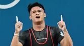 Rizki Juniansyah dari Indonesia melakukan selebrasi setelah memecahkan rekor di cabang olahraga angkat besi kelas 73kg putra selama Olimpiade Paris 2024 di South Paris Arena di Paris, pada 8 Agustus 2024 atau Jumat (9/8/2024) dini hari WIB. (Miguel MEDINA/AFP)