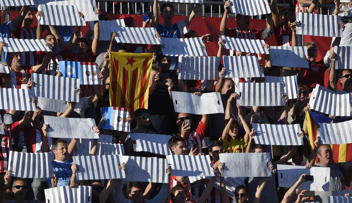 Aksi fans Girona memegang bendera Catalan saat timnya melawan Real Madrid pada lanjutan La Liga Santander di Municipal de Montilivi stadium, Girona , (29/10/2017). Madrid kalah 1-2. (AFP/Josep Lago)