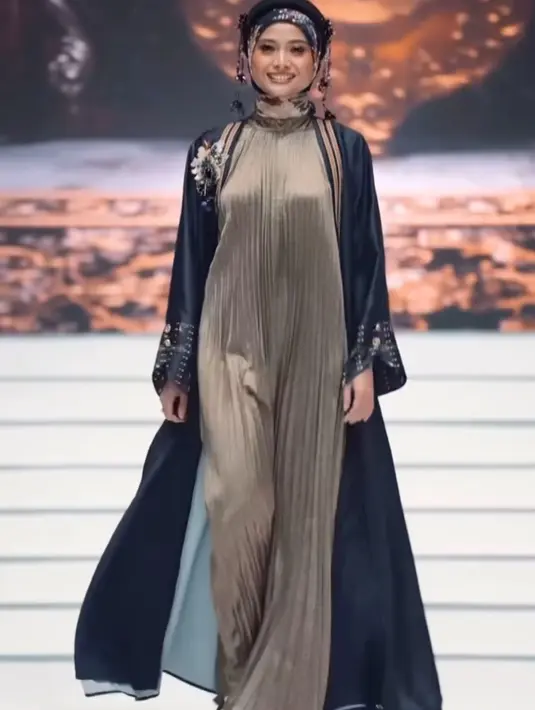 Acha Septriasa tampil dengan koleksi Zaskia Sungkar, mengenakan long dress plisket dipadukan outer panjang hitam bercorak serta kerudung bermotifnya.  [@zaskiasungkar15]