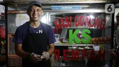 Mantan pegawai fungsional Biro Hukum Komisi Pemberantasan Korupsi (KPK), Juliandi Tigor Simanjuntak berpose di depan gerobak nasi goreng di pinggir Jalan Raya Hankam, Pondok Melati, Kota Bekasi, Rabu (13/10/2021). (Liputan6.com/Helmi Fithriansyah)