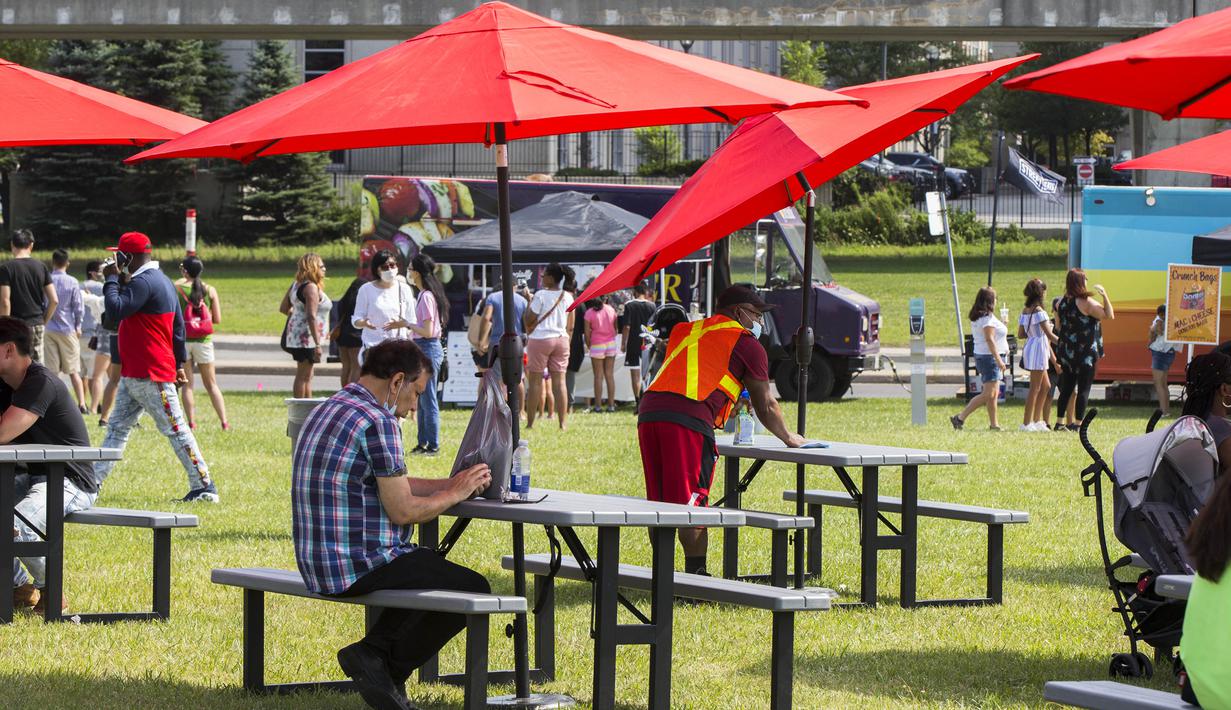 Seorang pekerja membersihkan meja saat Festival Es Krim Toronto di Toronto, Kanada, Sabtu (15/8/2020). Festival Es Krim Toronto diadakan pada 15-16 Agustus 2020 di tengah pandemi COVID-19. (Xinhua/Zou Zheng)