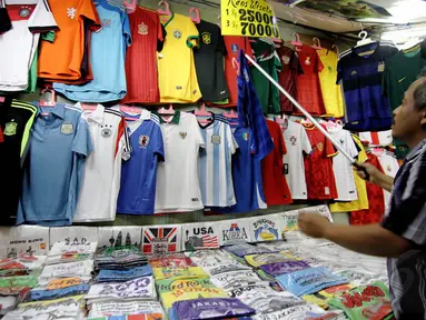 Seorang pedagang kaos tim peserta Piala Dunia 2014 menjajakan dagangannya di Pasar Baru, Jakarta, Rabu (11/6/14). (Liputan6.com/Faizal Fanani)