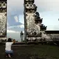 Turis asing foto di depan Gunung Agung yang meletus di Kabupaten Karangasem, Bali, (27/11). Sebelumnya, Gunung Agung telah mengalami erupsi sejak Sabtu (25/11) sore. (AP Photo / Firdia Lisnawati)