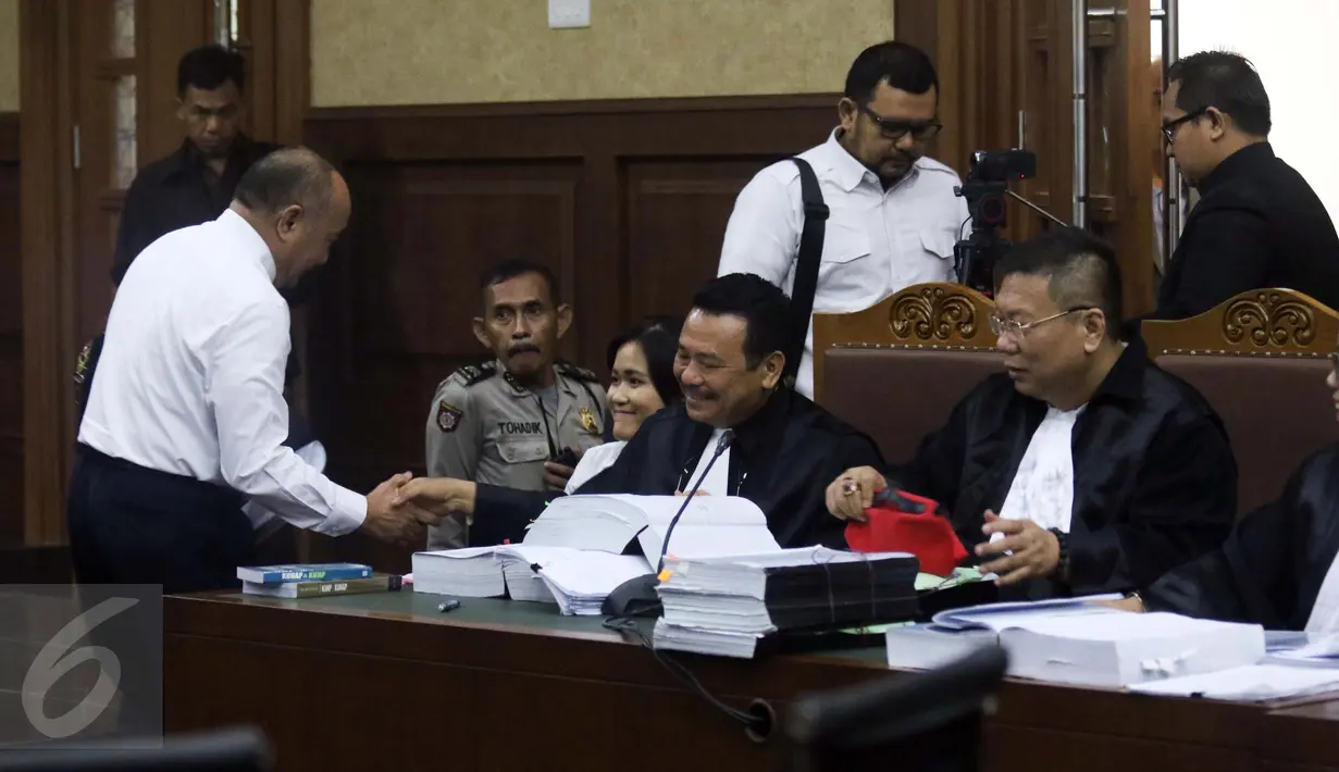Ahli forensik RSCM Budi Sampurna berjabat tangan dengan kuasa hukum Jessica Wongso usai sidang lanjutan di PN Jakarta Pusat, Rabu (31/8). Dalam persidangan ke-16 ini, JPU menghadirkan ahli forensik RSCM Budi Sampurna. (Liputan6.com/Helmi Afandi)