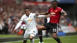 Pemain Manchester United, Antonio Valencia (kanan) berebut bola dengan pemain Swansea City, Martin Olsson pada lanjutan Premier League di Liberty Stadium, Swansea, (19/8/2017). MU menang 4-0. (Nick Potts/PA via AP)