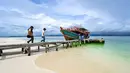 Di pulau ini, pengunjung dapat berenang, snorkeling, atau menikmati berbagai aktivitas air lainnya. Tampak dalam foto, orang-orang berjalan menuju perahu di Pulau Panjang, yang pernah menjadi objek sengketa perbatasan pulau antara Aceh dan Sumatera Utara, di Singkil, Provinsi Aceh bagian selatan, pada Rabu 12 November 2025. (CHAIDEER MAHYUDDIN/AFP)