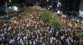 Para pengunjuk rasa mengangkat bendera dan plakat dalam unjuk rasa anti-pemerintah yang menuntut pembebasan warga Israel yang disandera oleh militan Palestina di Gaza sejak Oktober, di depan Kementerian Pertahanan Israel di Tel Aviv pada 14 September 2024. (Jack GUEZ/AFP)