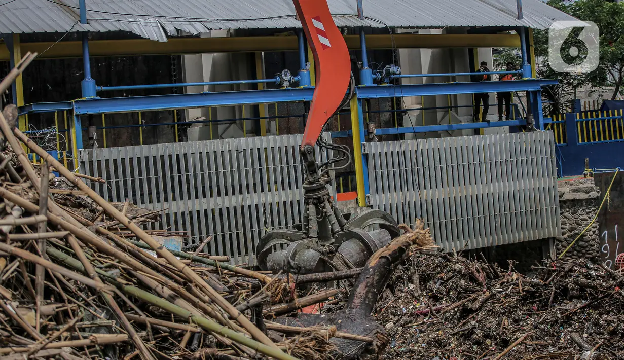 Pekerja kebersihan mengangkat sampah yang menumpuk di pintu air Manggarai, Jakarta, Selasa (22/9/2020). Tingginya curah hujan membuat kiriman sampah menumpuk di pintu air Manggarai. (Liputan6.com/Faizal Fanani)