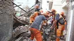 Petugas PPSU mengevakuasi sepeda motor yang tertimpa bangunan SMPN 32 Pekojan Jakarta Barat yang roboh pada Kamis (21/12). Diduga bangunan ini roboh karena usia yang sudah terlalu tua. (Liputan6.com/Herman Zakharia)