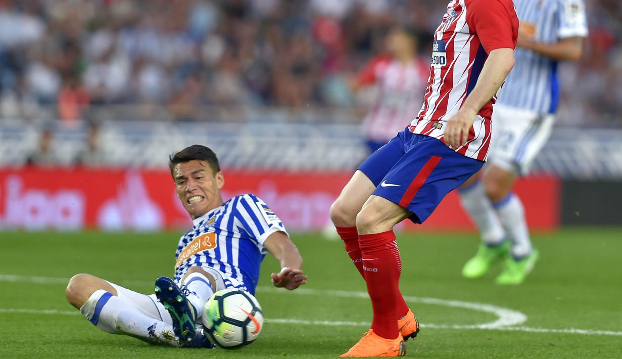 Bek Real Sociedad, Hector Moreno, merebut bola saat pertandingan melawan Atletico Madrid pada laga La Liga di Stadion Municipal de Anoeta, Kamis (19/4/2018). Real Sociedad menang 3-0 atas Atletico Madrid. (AFP/Ander Gillenea)