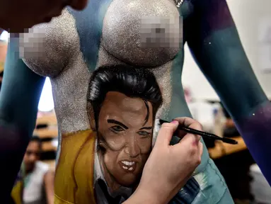 Seorang model menunjukkan tubuhnya dilukis oleh mahasiswa seni lembaga Chili AIEP selama pameran body painting, Santiago (24/11/2015). Lebih dari 100 desain yang terinspirasi oleh ikon musik, dipamerkan dalam pameran tersebut (AFP Photo/Martin Bernetti)