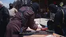 Algojo membalut tangan terpidana menggunakan perban usai eksekusi potong tangan Distrik Al-Karama, Mosul, Irak. Hukum syariah lainnya yang juga diterapkan ISIS yaitu hukuman cambuk. (Handout via Reuters)