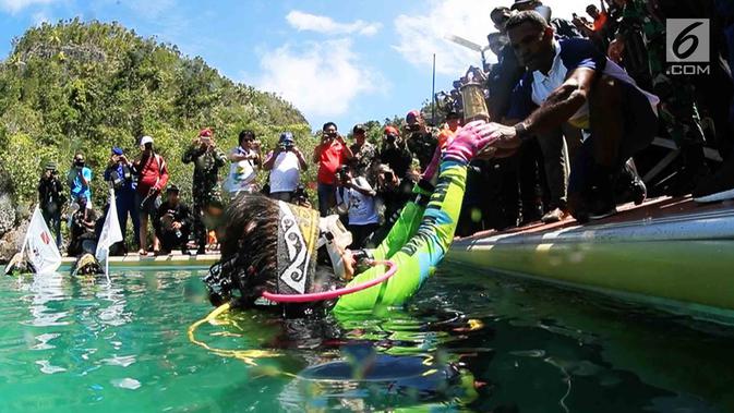 Ketua Umum WASI, Tri Suswati Karnavian membawa api obor Asian Games 2018 di perairan Pulau Piaynemo, Raja Ampat, Papua Barat, Kamis (26/7). Kegiatan ini sebagai bentuk dukungan perempuan terhadap kesuksesan Asian Games 2018. (Liputan6.com/HO/Mabes Polri)