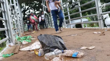 Kemasan botol air mineral berceceran di koridor Jembatan Penyebrangan Orang (JPO) Jalan Medan Merdeka Barat, Jakarta, Selasa (1/1). Pasca malam perayaan pergantian tahun JPO Medan Merdeka Barat masih tampak kotor. (Liputan6.com/Helmi Fithriansyah)