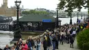Orang-orang berjalan melewati Riverside Cafe saat mengantre untuk memberi penghormatan kepada mendiang Ratu Elizabeth II di Westminster Hall, London pada 15 September 2022. Hotel, restoran, dan toko-toko penuh sesak saat penggemar kerajaan berdatangan ke jantung kota London untuk melihat jalan-jalan yang dipagari bendera, prosesi yang dipenuhi kemegahan, dan berani mengantre sejauh bermil-mil untuk mengucapkan selamat tinggal kepada Ratu Elizabeth II. (AP Photo/Petr David Josek, File)