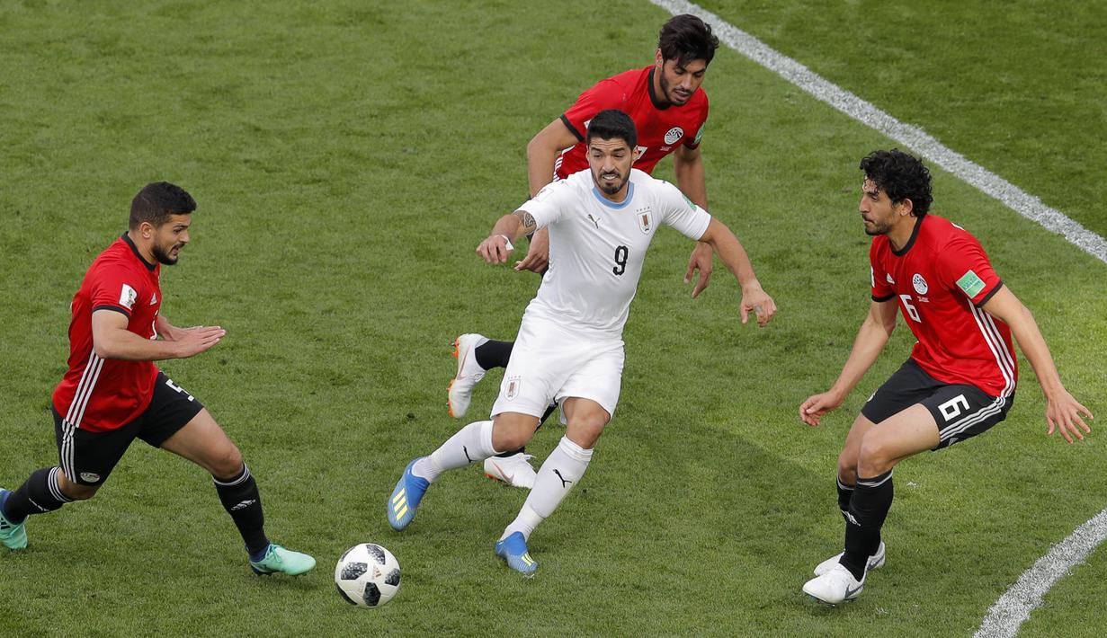 Striker Uruguay, Luis Suarez, berebut bola dengan gelandang Mesir, Sam Morsy, pada laga Piala Dunia di Stadion Ekaterinburg, Jumat (15/6/2018). Uruguay menang 1-0 atas Mesir. (AP/Vadim Ghirda)