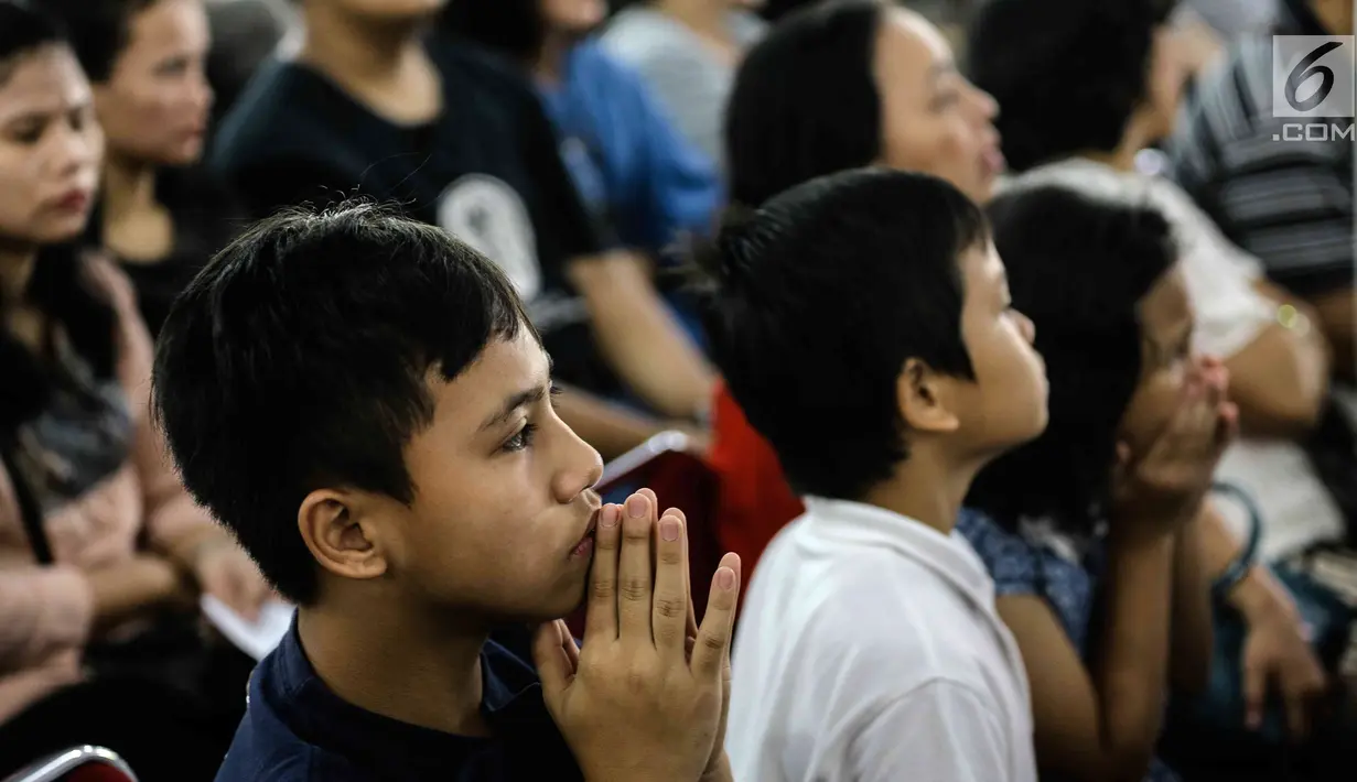 Sejumlah jemaat anak-anak mengikuti dengan khusyuk prosesi jalan salib di Gereja Katedral, Jakarta, Jumat (30/3). Rangkaian perjalanan Yesus yang divisualisasikan ini terdiri dari 14 peristiwa. (Liputan6.com/Faizal Fanani)