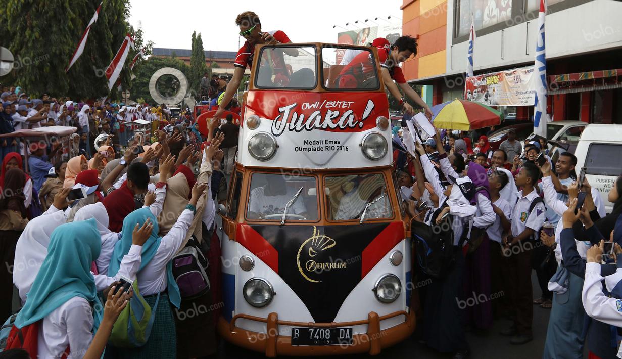 Peraih emas bulutangkis Olimpiade Rio 2016, Tontowi Ahmad dan Liliyana Natsir, disambut warga Kudus saat kirab melewati alun-alun kota Kudus, Kamis (1/9/2016). (Bola.com/Arief Bagus)
