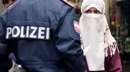 Wanita muslim menatap petugas kepolisian yang merazia penggunaan cadar di tempat umum di kota Zell am See, Minggu (1/10). Pemerintah Austria mengeluarkan undang-undang baru yang melarang seseorang menggunakan penutup wajah. (BARBARA GINDL/APA/AFP)