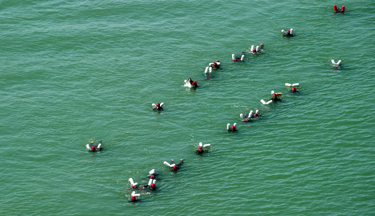 Aksi sekitar 2000 prajurit Korps Marinir TNI AL berenang melintasi selat Madura dari Surabaya sepanjang 5,4 kilometer, Kamis (28/4). Museum Rekor Indonesia (MURI) mencatat, kegiatan tersebut memecahkan rekor peserta terbanyak. (Juni KRISWANTO/AFP)