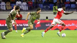 Gelandang Arsenal, Thomas Partey membawa bola dari kejaran gelandang AC Milan, Yacine Adli dan Sandro Tonali selama pertandingan Dubai Super Cup 2022 di di stadion al-Maktoum di Uni Emirat Arab (13/12/2022). Arsenal menang tipis atas AC Milan dengan skor 2-1. (AFP/Karim Sahib)