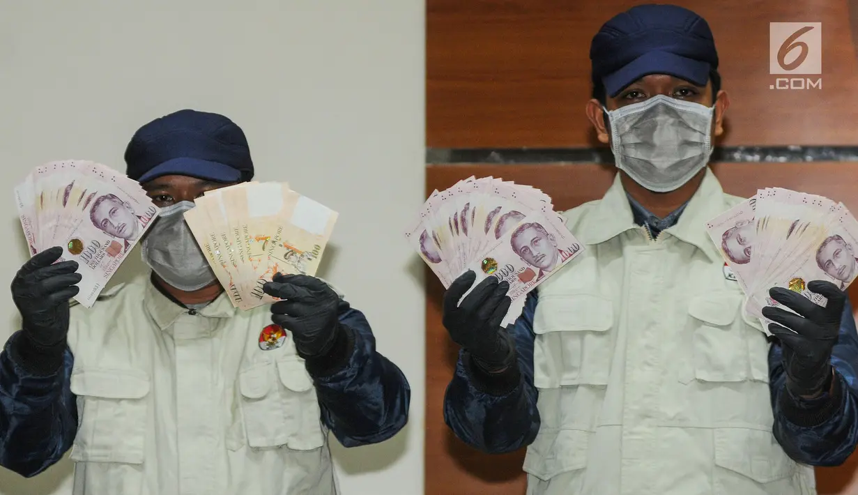 Petugas KPK menunjukkan barang bukti uang SGD 96.700 hasil OTT di Gedung KPK, Kamis (1/8/2019). KPK menetapkan Direktur Keuangan PT Angkasa Pura (AP) II Andra Y Agussalam sebagai tersangka kasus dugaan suap proyek pengadaan baggage handling system (BHS). (merdeka.com/Dwi Narwoko)
