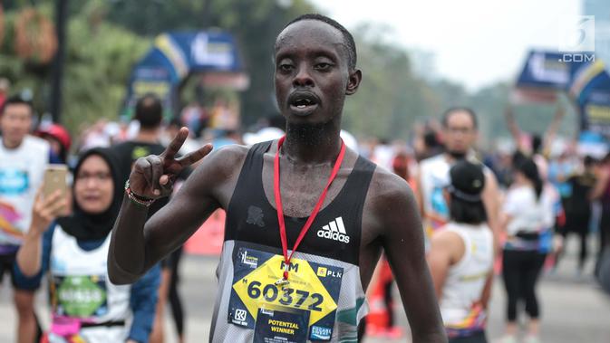 Pelari kenya Bernard Mwendia Muthoni usai menyelesaikan lari Full Marathon dalam Jakarta Marathon 2018 di GBK, Jakarta, Minggu (28/10). Bernard berhasil sampai finish kategori Full Marathon dalam catatan waktu 02:19:10. (Liputan6.com/Faizal Fanani)
