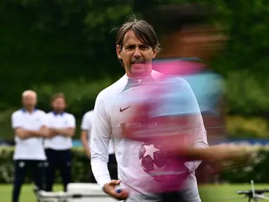 Pelatih Inter Milan, Simone Inzaghi menyaksikan pemainnya berlari selama sesi latihan tim  di tempat latihan klub di Appiano Gentile, utara Milan, pada 5 Juni 2023. (AFP/Gabriel Bouys)