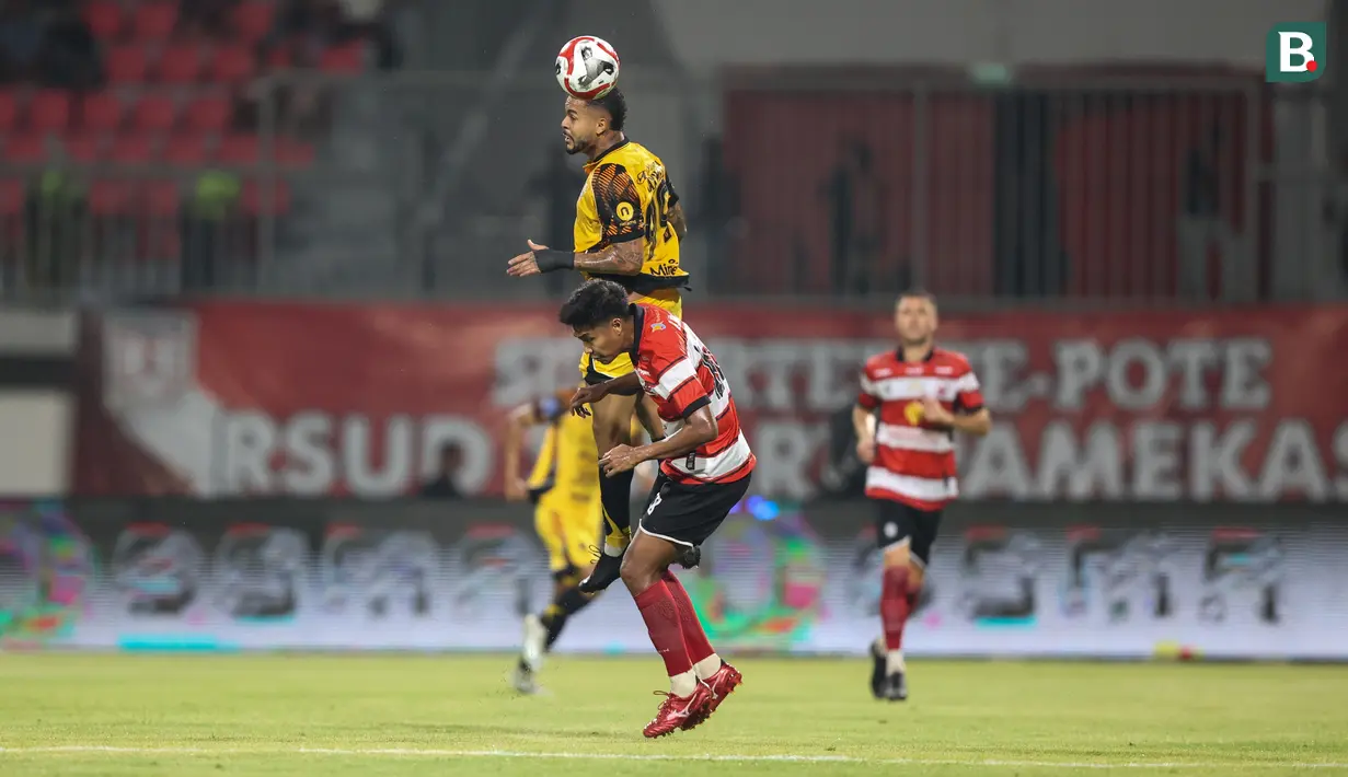 Pemain Persija Jakarta, Emaxwell (atas) berduel dengan pemain Madura United pada lanjutan BRI Super League 2025/2026 di Stadion Gelora Ratu Pamelingan, Jumat (24/10/2025) malam WIB. (Bola.com/Abdul Aziz).