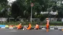 Petugas PPSU Gondangdia mengecat pembatas jalan dengan warna-warni Asian Games di kawasan Menteng, Jakarta, Kamis (12/7). Cat lukisan dinding beraneka gambar dan bentuk untuk menyambut HUT kemerdekaan RI dan Asian Games 2018. (Liputan6.com/Arya Manggala)