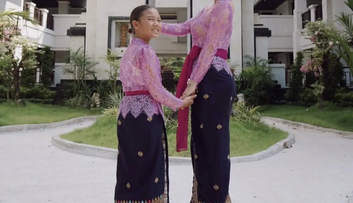 Jennifer Bachdim dan sang putri tampil kompak dengan kebaya Bali warna ungu dipadukan kain lilit hitam sebagai bawahan, lengkap mengenakan obi warna magenta. @jenniferbachdim