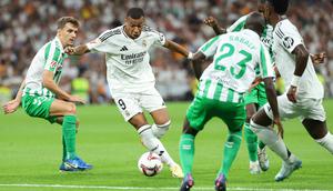 Pemain Real Madrid, Kylian Mbappe (kedua kiri) berusaha melewati penjagaan dari sejumlah pemain Real Betis pada laga lanjutan Liga Spanyol 2024/2025 di Santiago Bernabeu, Madrid, Spanyol, Senin (02/09/2024) WIB. (AFP/Thomas Coex)
