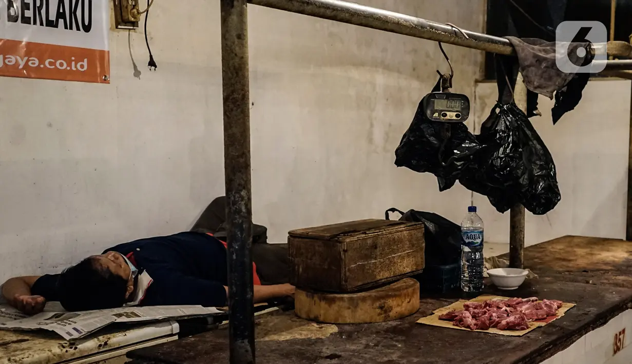 Seorang pria tidur di los daging non halal di Pasar Senen, Jakarta, Senin (13/9/2021). Manajer Umum dan Humas Perumda Pasar Jaya Gatra Vaganza mengatakan pihaknya sudah memanggil dan memberi sanksi administrasi kepada pedagang daging anjing di Pasar Senen Blok III tersebut (Liputan6.com/Johan Tallo)