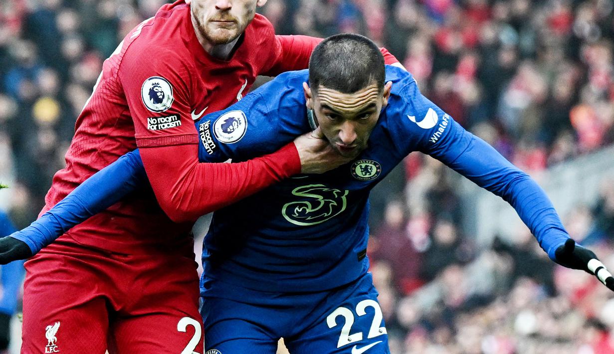 Pemain Chelsea, Hakim Ziyech, diadang pemain Liverpool,  Andrew Robertson, pada laga Liga Inggris di Stadion Anfield (21/1/2023). Impian Hakim Ziyech bermain bersama Lionel Messi, Neymar, Kylian Mbappe, dan sahabat baiknya Achraf Hakimi, gagal total. Transfernya sebagai pemain pinjaman ke PSG batal di akhir-akhir bursa transfer bulan Januari 2023 karena The Blues salah mengirim dokumen. (AFP/Paul Ellis)