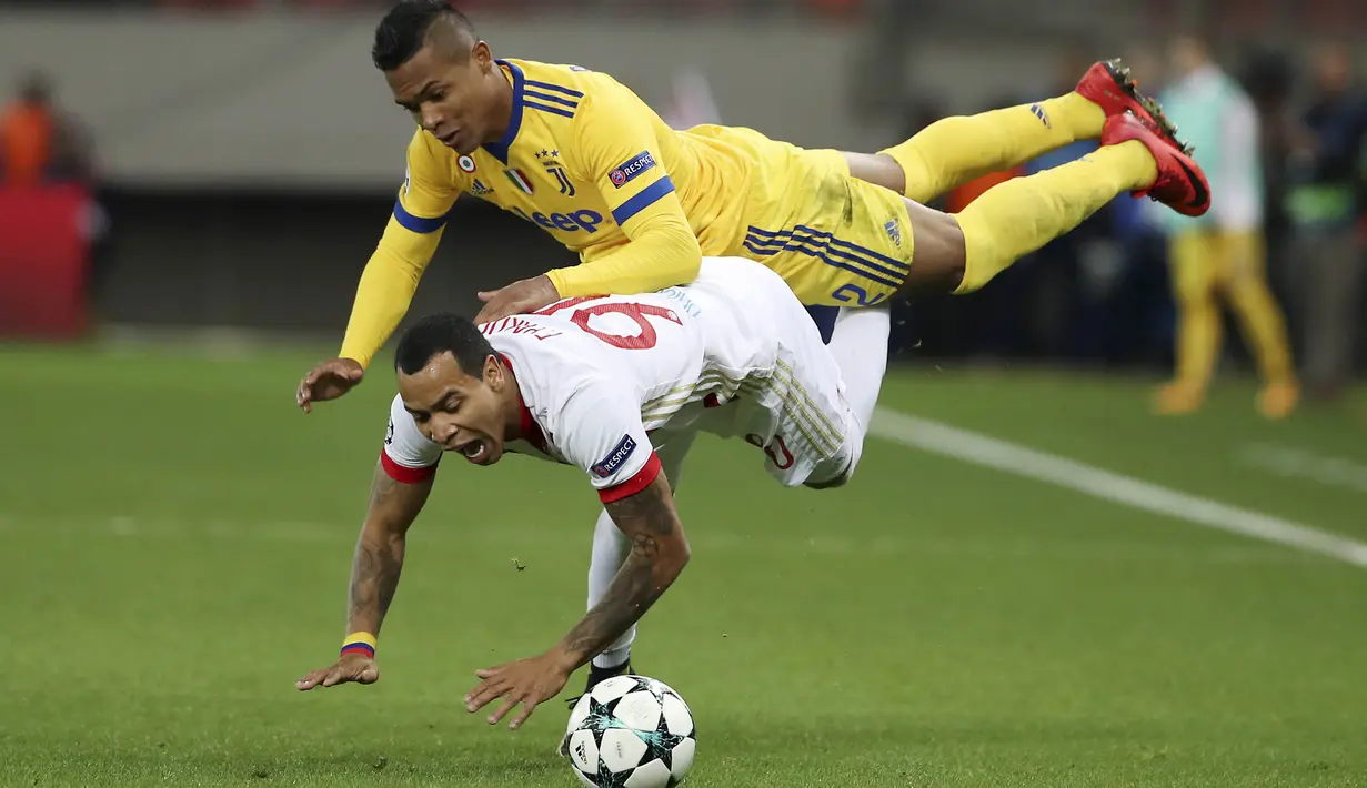 Gelandang Olympiakos,  Felipe Pardo, terjatuh saat berebut bola dengan bek Juventus, Alex Sandro, pada laga Liga Champions di Stadion Georgios Karaiskakis, Rabu (6/12/2017). Juventus menang 2-0 atas Olympiakos. (AFP/Petros Giannakouris)