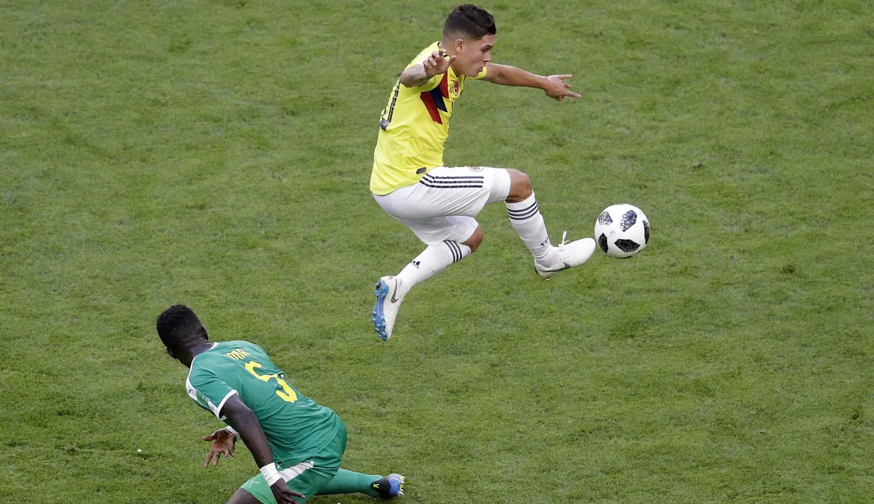 Aksi pemain Kolombia, Juan Quintero (atas) mengontrol bola saat duel dengan pemain Senegal, Idrissa Gana Gueye pada laga terakhir grup H di Samara Arena, Samara, Rusia, (28/6/2018). Kolombia menang 1-0. (AP/Gregorio Borgia)