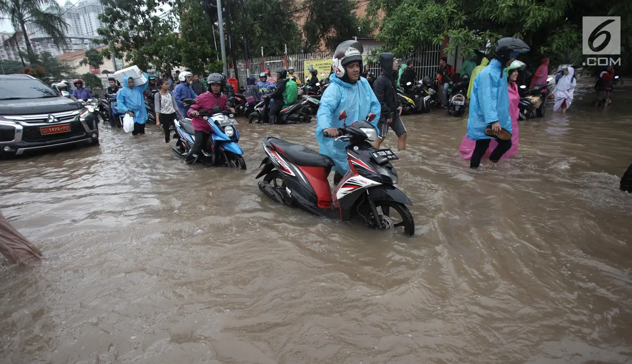 Sejumlah pengendara sepeda motor mendorong kendaraannya saat melintasi banjir di Jalan Boulevard Barat Raya, Kelapa Gading, Jakarta, Kamis (15/2). Hujan lebat yang mengguyur Jakarta mengakibatkan sejumlah wilayah kebanjiran. (Liputan6.com/Arya Manggala)