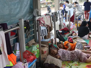 Warga korban banjir mengungsi di Halte Transjakarta Jembatan Baru, Cengkareng, Jakarta, Jumat (3/1/2020). Warga sekitar terpaksa mengungsi ke Halte Transjakarta Jembatan Baru karena rumah mereka masih terendam banjir. (Liputan6.com/Angga Yuniar)